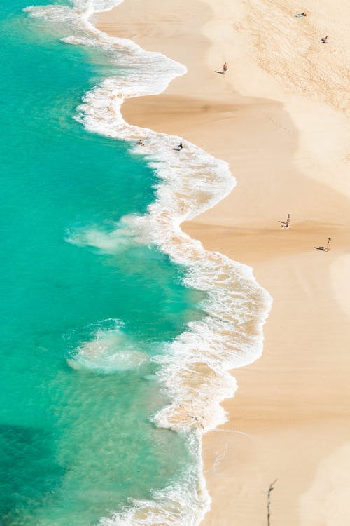 绿松石的泡沫海冲刷的沙质海岸线 · 免费素材图片