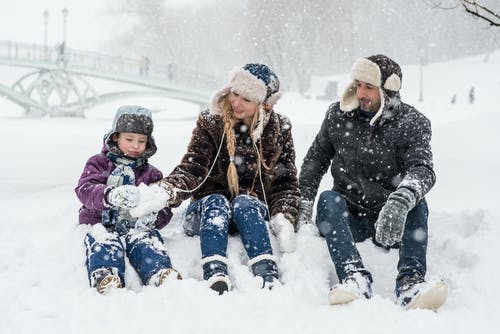 女人，男人和女孩坐在雪地上 · 免费素材图片