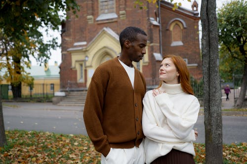 站在白色的长袖衬衫的女人旁边的棕色毛衣的男人 · 免费素材图片