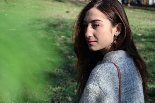 在草地旁边的灰色毛衣的女人 · 免费素材图片