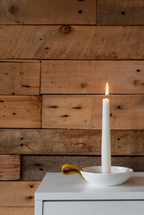 在房子的木墙附近的明亮燃烧的蜡烛 · 免费素材图片