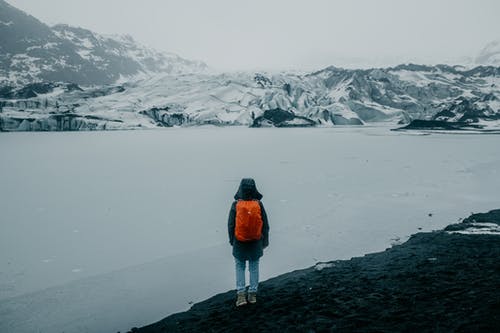 橙色外套站在雪地上的人 · 免费素材图片