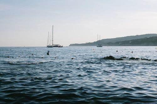帆船在山附近荡漾的大海 · 免费素材图片