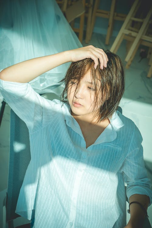 女人抚摸她的头发的照片 · 免费素材图片