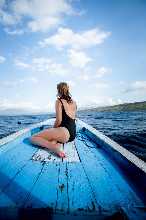 女人坐在木船上的照片 · 免费素材图片