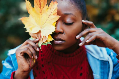 女人覆盖脸与棕色叶的选择性聚焦摄影 · 免费素材图片