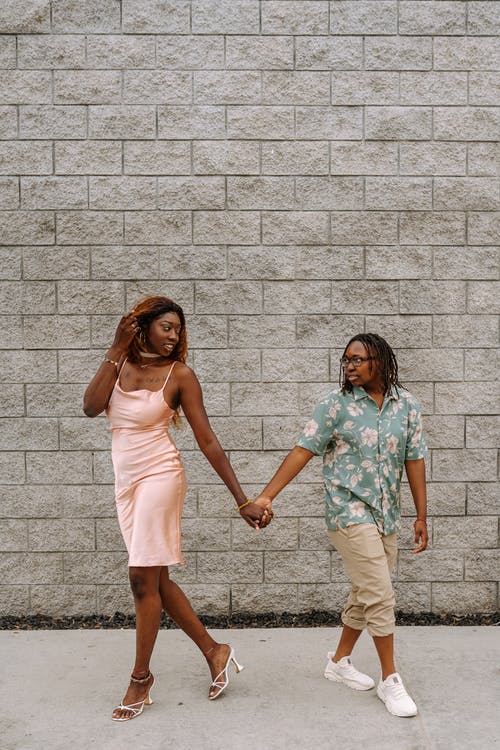 2名妇女站在砖墙旁边 · 免费素材图片