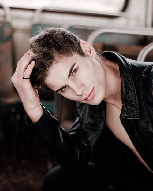 男人抚摸他的头发的选择性焦点摄影 · 免费素材图片