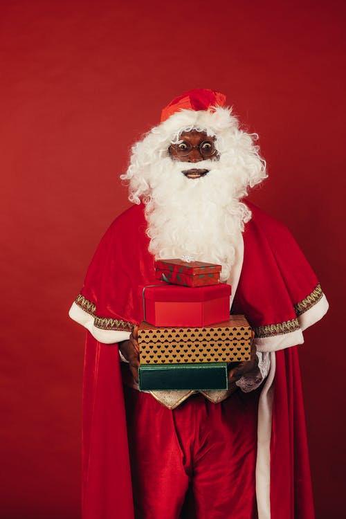圣诞老人在红色背景上举行圣诞礼物 · 免费素材图片