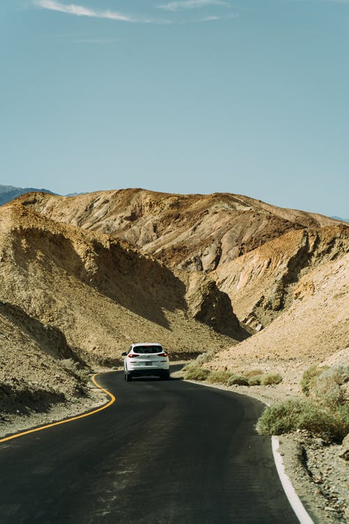 岩石之间的道路上的白色车 · 免费素材图片