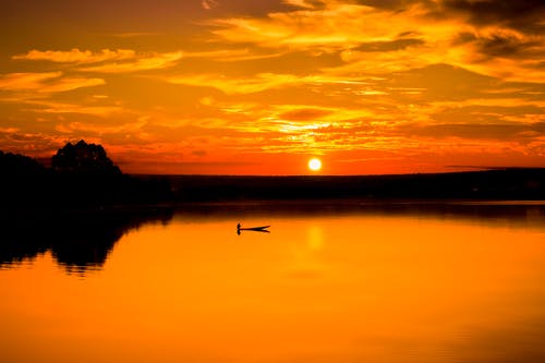 如画的风景，在日落时多云的天空下的明亮湖 · 免费素材图片