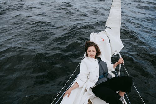 坐在白船上的白大衣的女人 · 免费素材图片