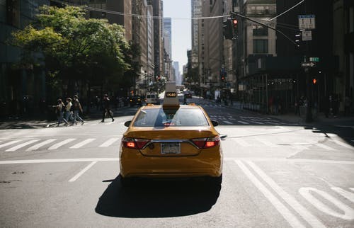 在城市道路上的现代黄色出租车 · 免费素材图片