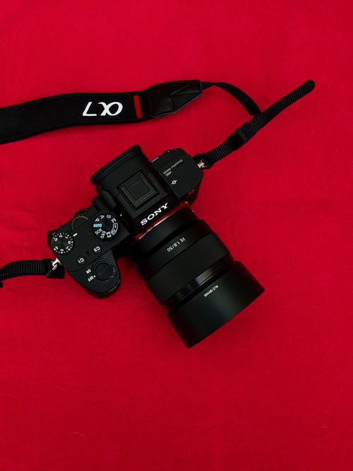 红色背景上的黑色数码相机 · 免费素材图片