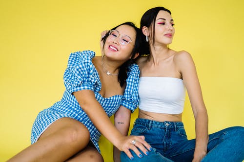 白色抹胸的女人旁边蓝色和白色格仔的恤衫的女人 · 免费素材图片