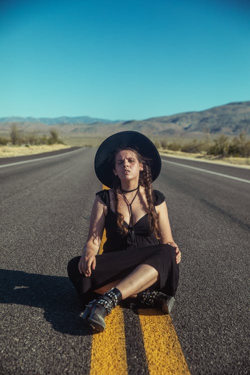 黑色背心和黑色的裤子，坐在路上的女人 · 免费素材图片