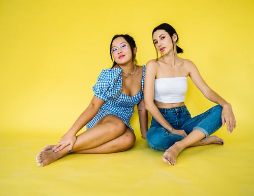 坐在黄色地板上的蓝色牛仔短裤的女人 · 免费素材图片