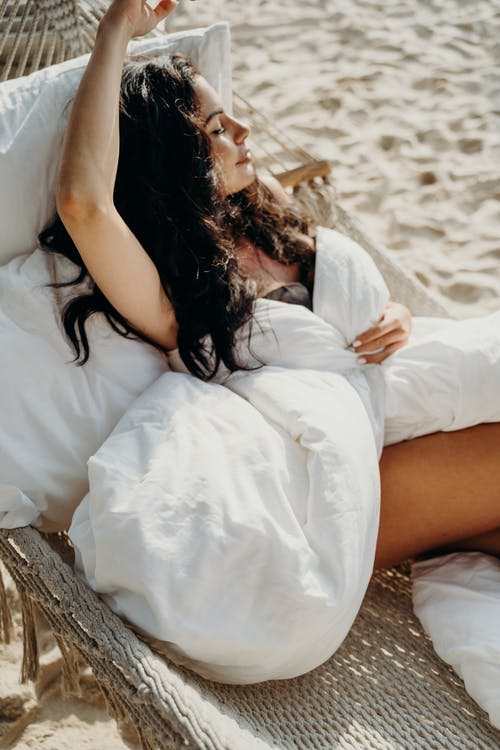 躺在棕色的木日志上的白色连衣裙的女人 · 免费素材图片