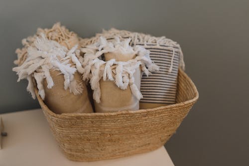 棕色编织篮子上的白色纺织品 · 免费素材图片