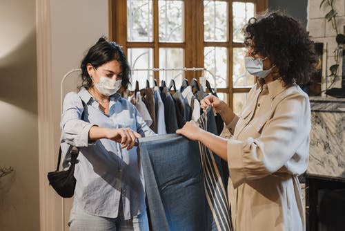 拿着蓝色牛仔牛仔裤的白大衣的女人 · 免费素材图片