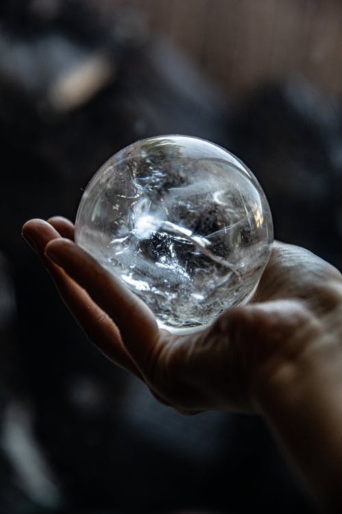 持有透明玻璃球的人 · 免费素材图片