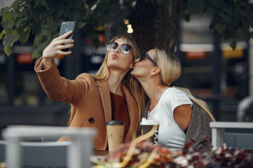 有关墨鏡, 女性, 智慧手機的免费素材图片