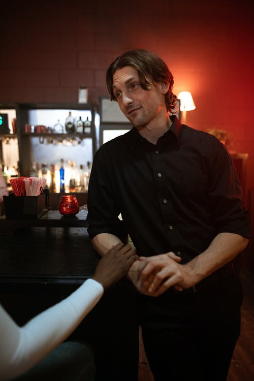 衬衫坐在黑色的木桌上的黑色按钮的人 · 免费素材图片