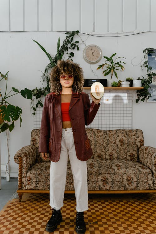 一个女人拿着切成两半的西瓜 · 免费素材图片