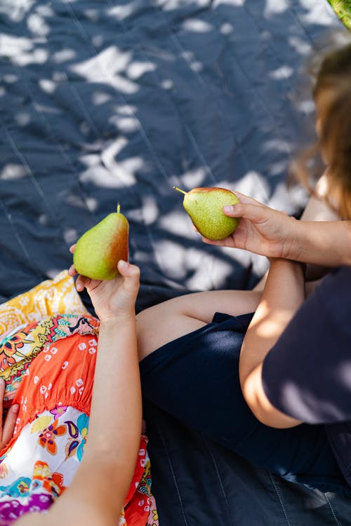 有关垂直拍摄, 手, 梨子的免费素材图片