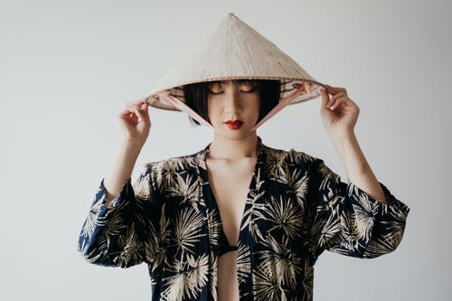 拿着棕色帽子的黑白花卉长袖衬衣的妇女 · 免费素材图片