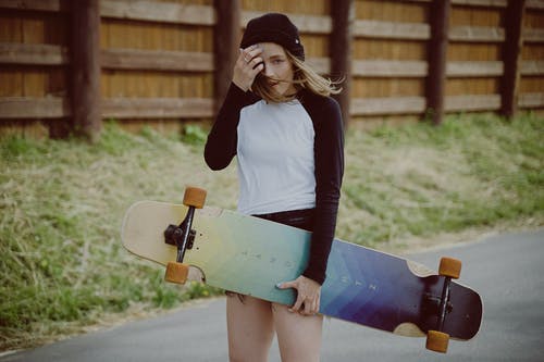 白色的长袖衬衫和蓝色的牛仔裙，拿着滑板的女人 · 免费素材图片