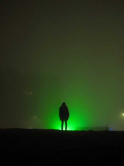 夜间站在山上的人的身影 · 免费素材图片