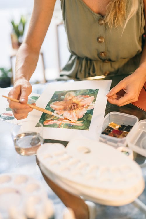 持白色和棕色花卉印花卡的人 · 免费素材图片