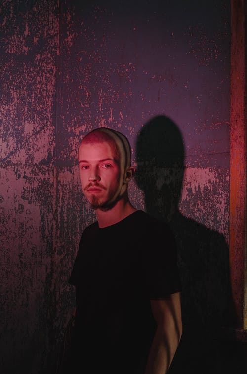 站在墙上的男人的照片 · 免费素材图片