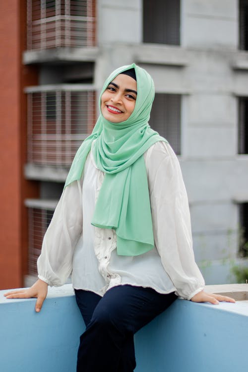 有关坐, 微笑, 水泥牆的免费素材图片