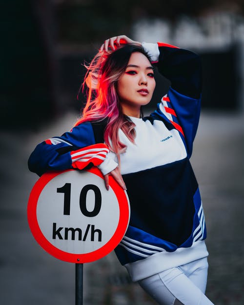 女人靠着10公里/小时的标牌 · 免费素材图片