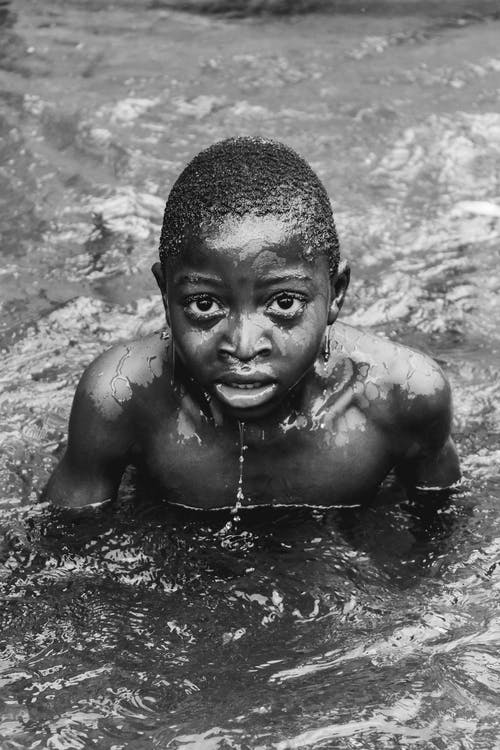 裸照男孩在水面上的灰度照片 · 免费素材图片