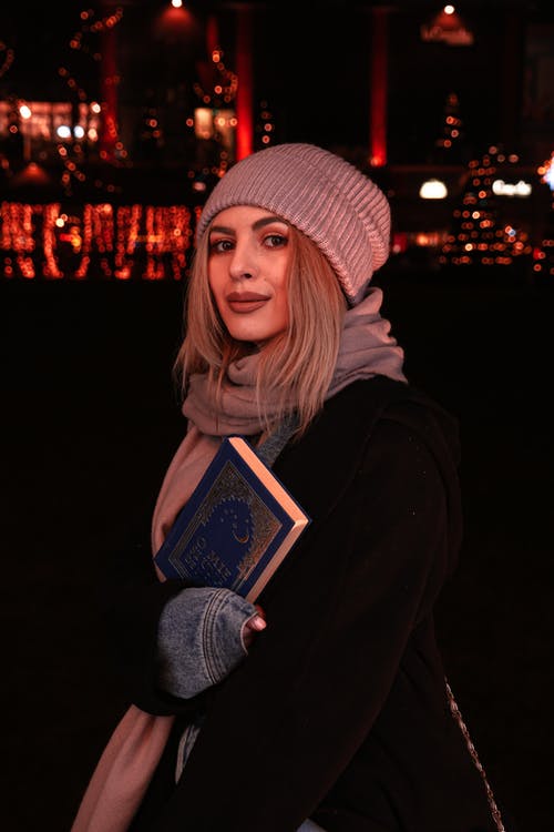 拿着本书的黑外套的女人 · 免费素材图片