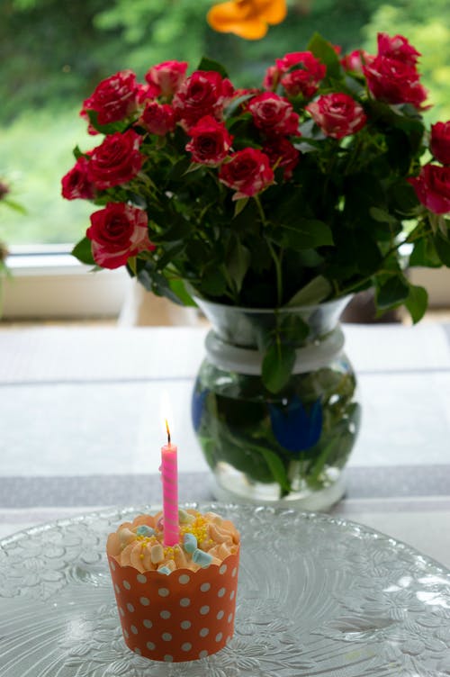 有关垂直拍摄, 杯子小蛋糕, 点燃的蜡烛的免费素材图片