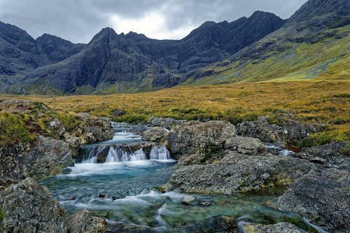 绿草覆盖的山附近的瀑布 · 免费素材图片
