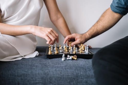 拿着棋子的白色连衣裙的人 · 免费素材图片