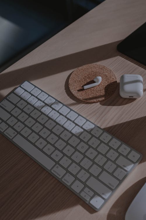 苹果魔术键盘棕色木制的桌子上 · 免费素材图片