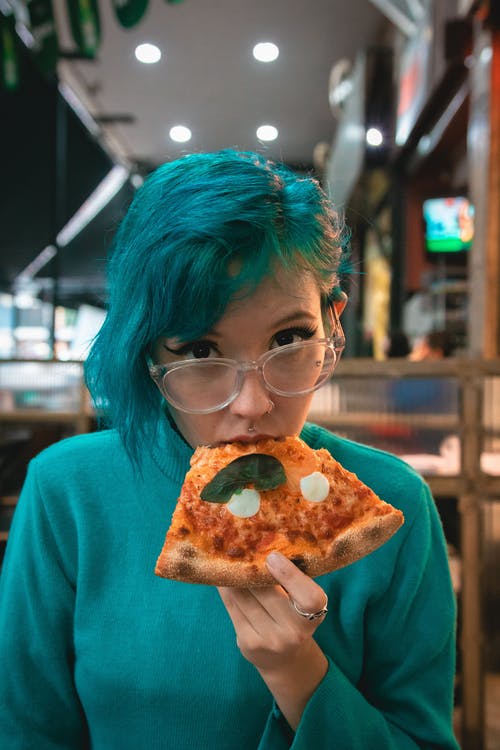 绿头发的女人吃披萨 · 免费素材图片