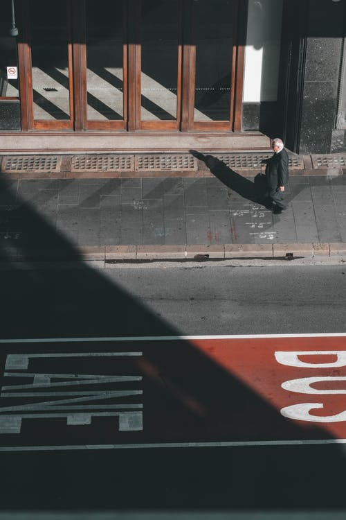 黑夹克和裤子站在人行道上的男人 · 免费素材图片