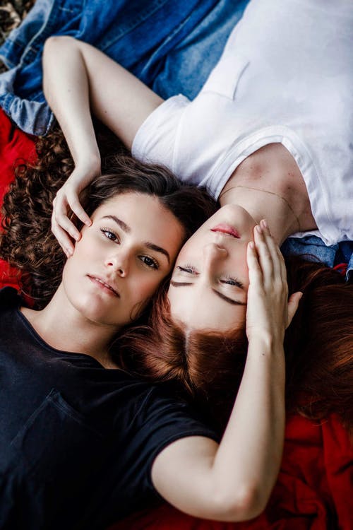 躺在红色和蓝色毯子上的两个女人 · 免费素材图片