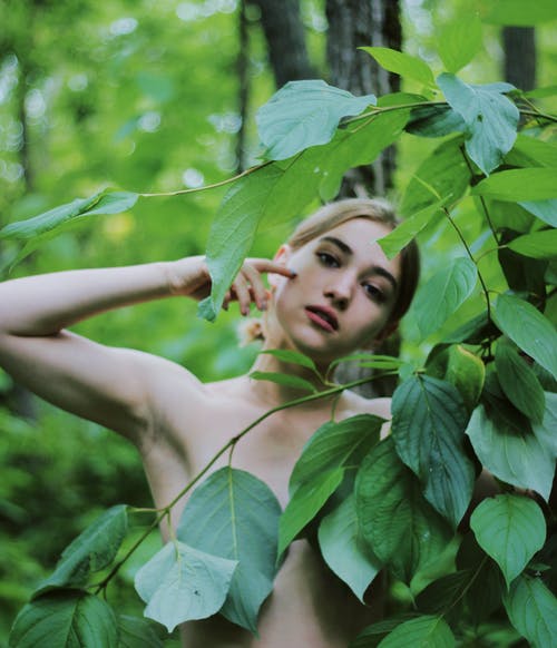 隐藏在绿色的树叶上的白色背心的女人 · 免费素材图片