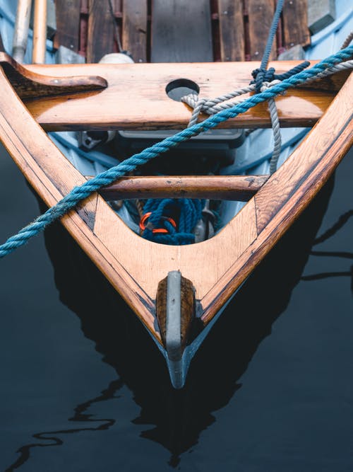 绑在水面上的棕色木船上的绳索 · 免费素材图片
