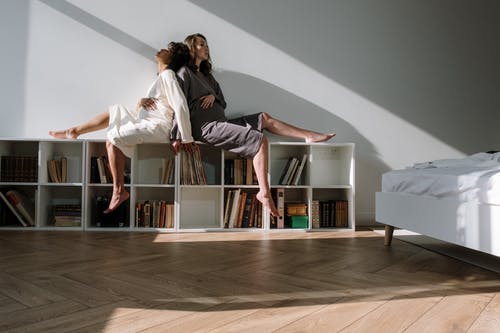 白色长袖衬衫和黑色的裤子，站在灰色长袖的女人旁边的女人 · 免费素材图片