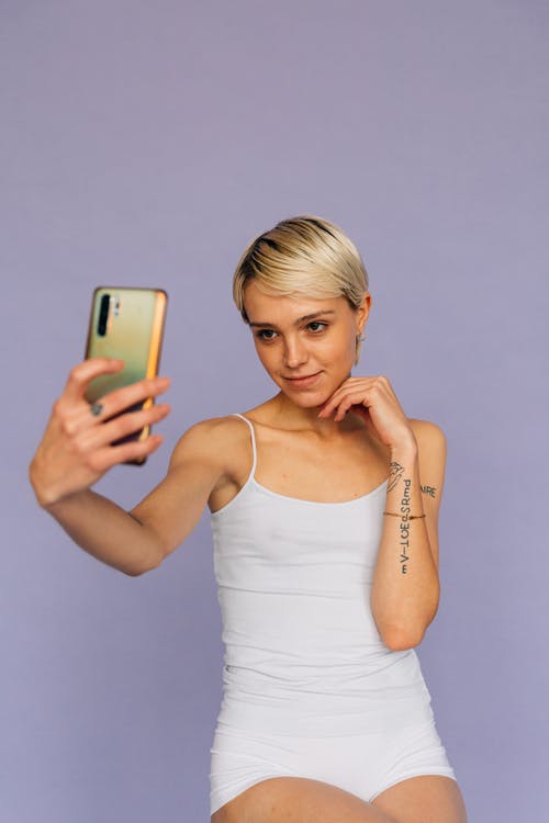 拿着金iphone 6的白色背心的女人 · 免费素材图片