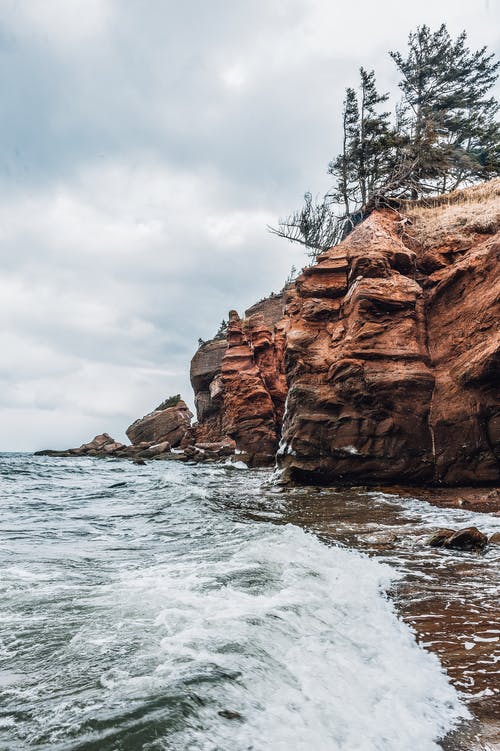 在水体旁边的岩石峭壁 · 免费素材图片